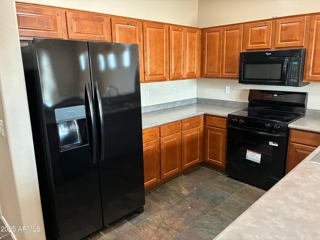 a kitchen with stainless steel appliances granite countertop a refrigerator and a sink
