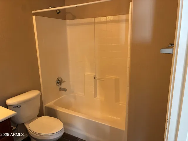 a white toilet sitting next to a bath tub