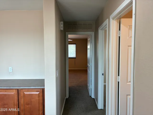 a view of a hallway with closet and bathroom