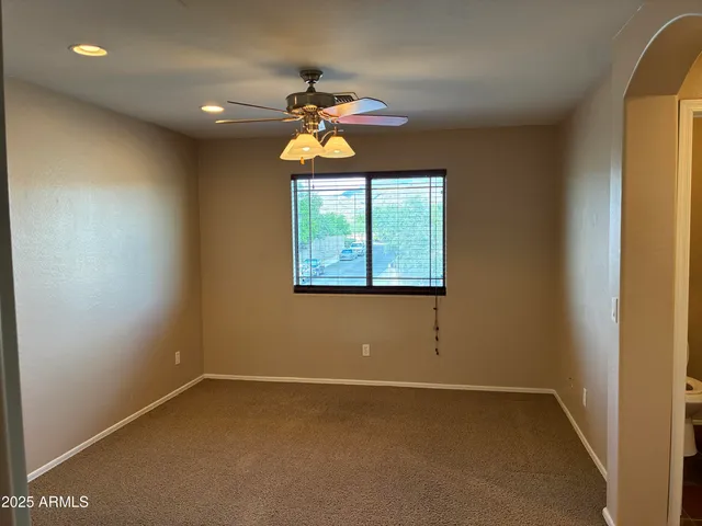an empty room with a window and chandelier