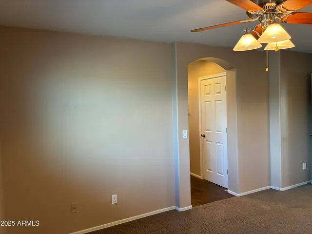 a view of a hallway with a chandelier fan and a livingroom