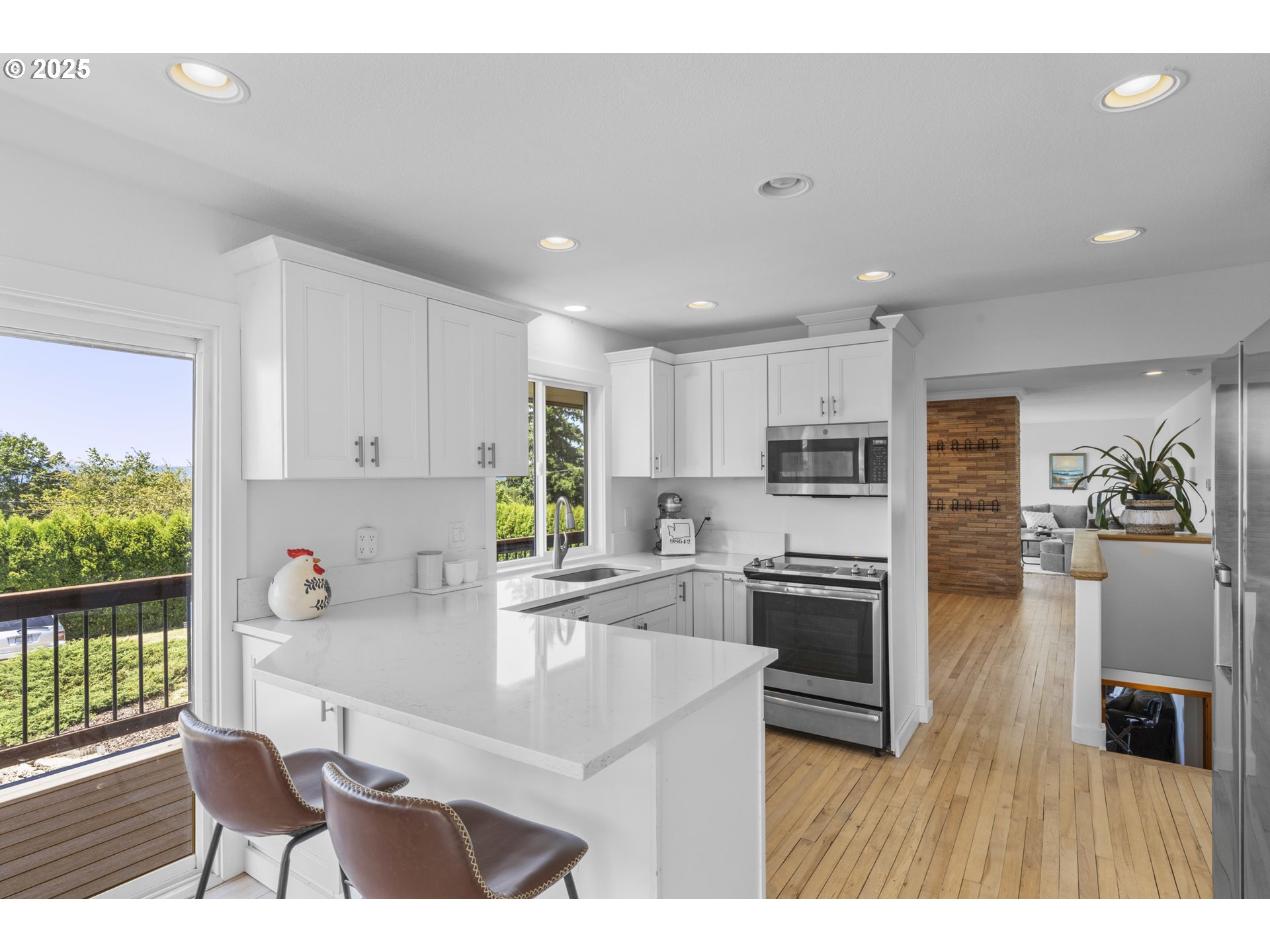 470 South 9th Court Ridgefield, WA 98642 - Photo 10 of 47 a kitchen with a stove a refrigerator and a dining table with wooden floor