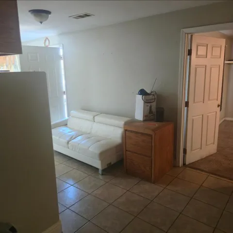 a living room with patio furniture and a floor to ceiling window