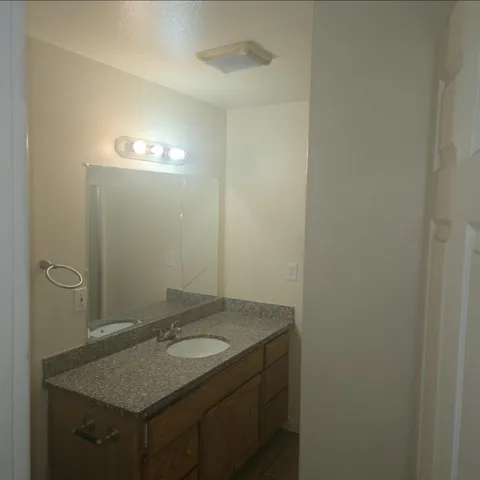 a bathroom with a granite countertop sink and a mirror
