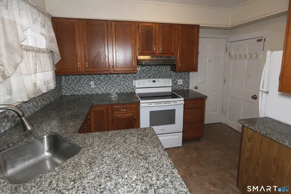 a kitchen with stainless steel appliances granite countertop a stove a sink and a microwave