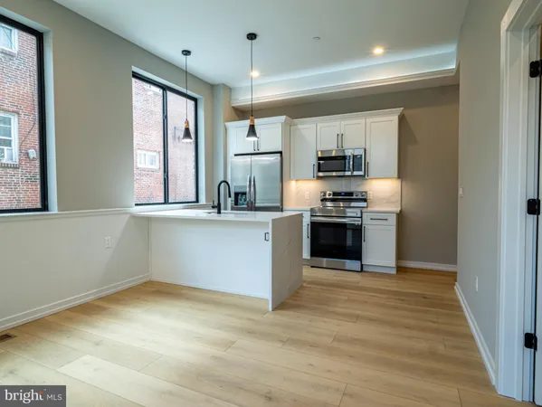 a kitchen with granite countertop a stove top oven and cabinets