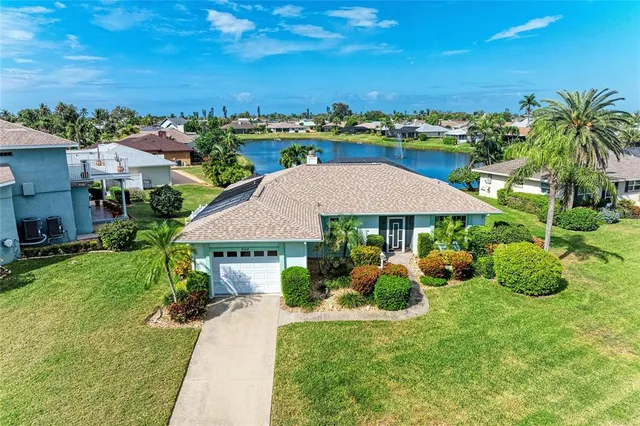an aerial view of a house with yard and lake view