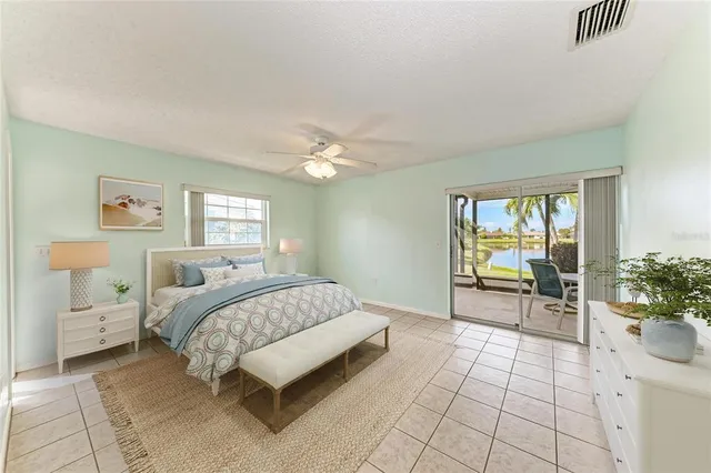 a spacious bedroom with a bed and table chair