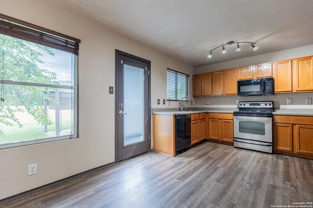 a kitchen with granite countertop a stove top oven and sink