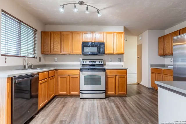 a kitchen with stainless steel appliances granite countertop a stove sink and cabinets