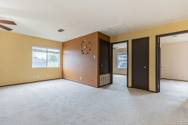 a view of an empty room with window and closet