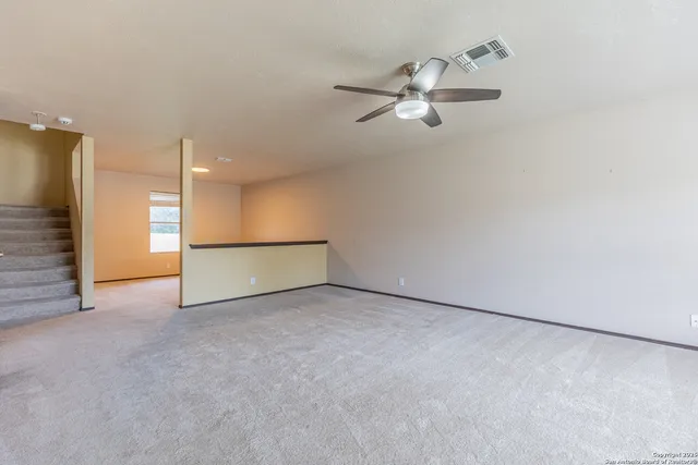 an empty room with fan and windows