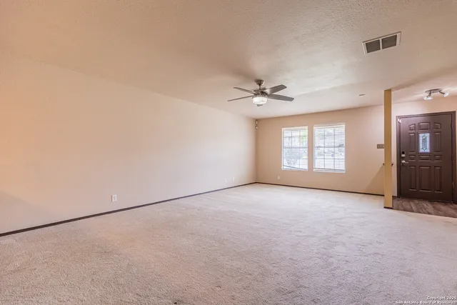 an empty room with windows & cabinet