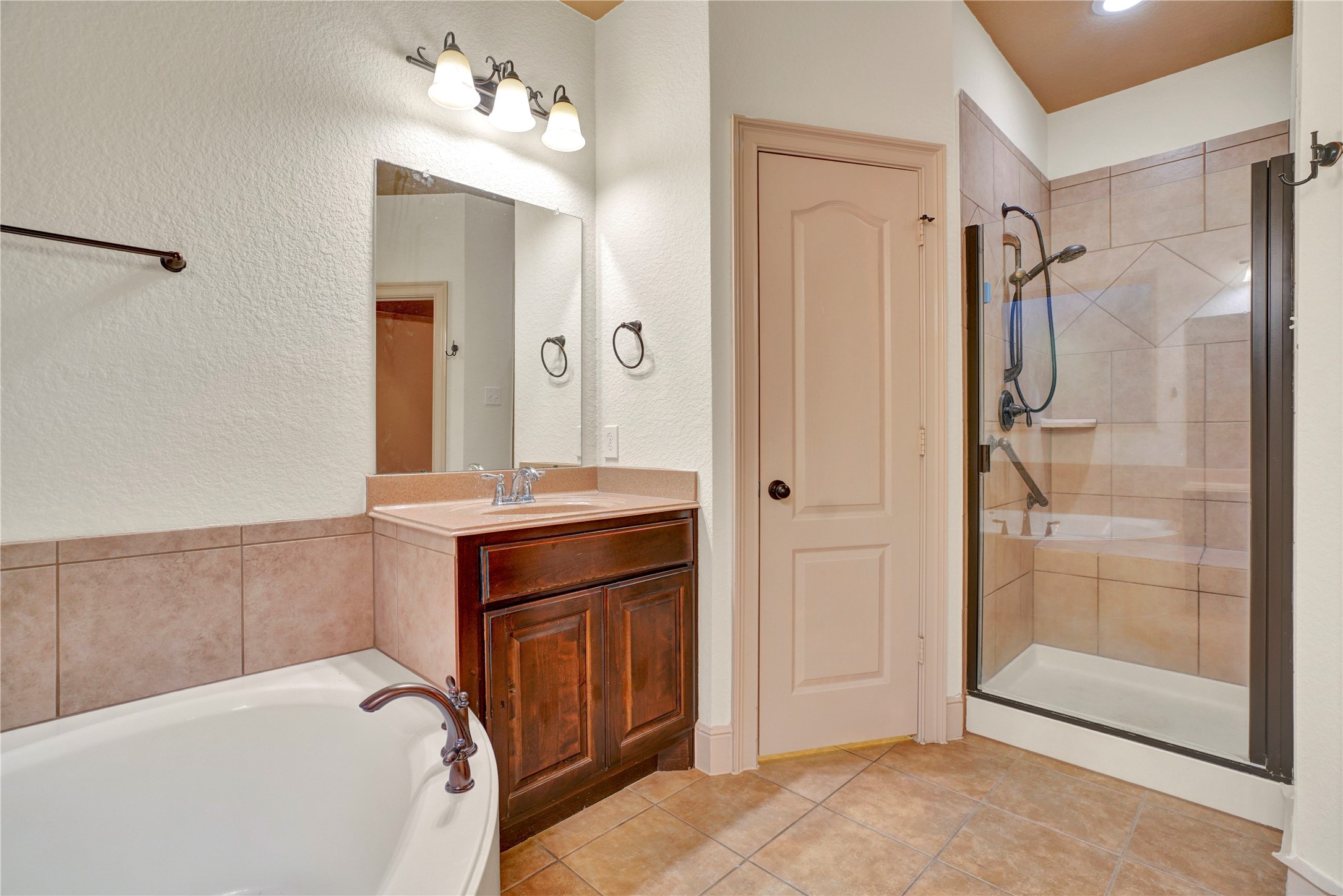 10 Tallgrass Way Spring, TX 77389 - Photo 16 of 23 a bathroom with a tub shower sink and mirror