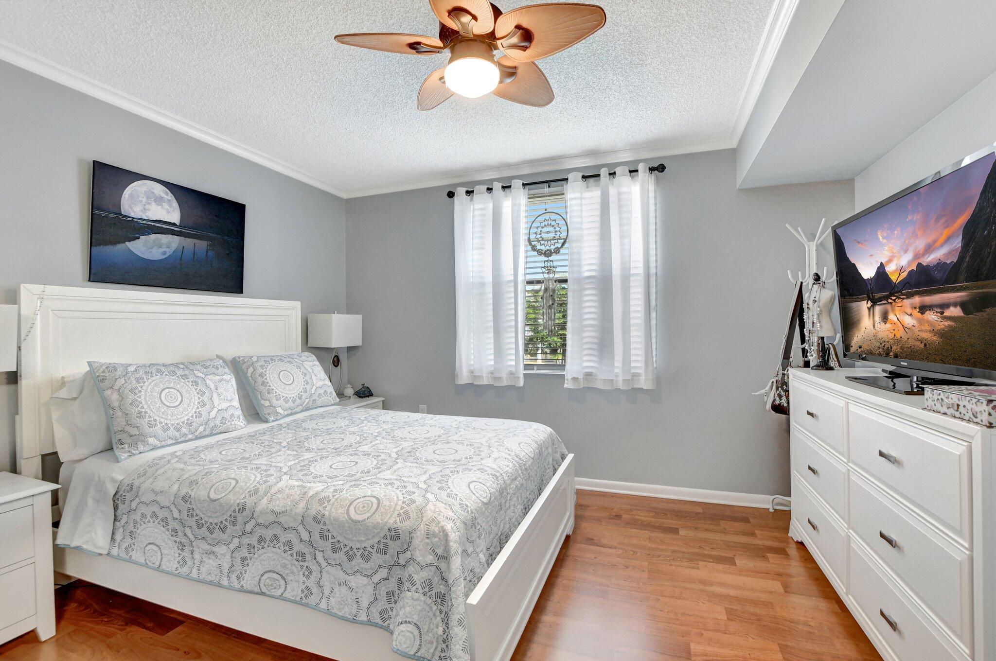 6025 Balboa Circle, Unit 303 Boca Raton, FL 33433 - Photo 15 of 23 a bedroom with a large bed and a flat screen tv