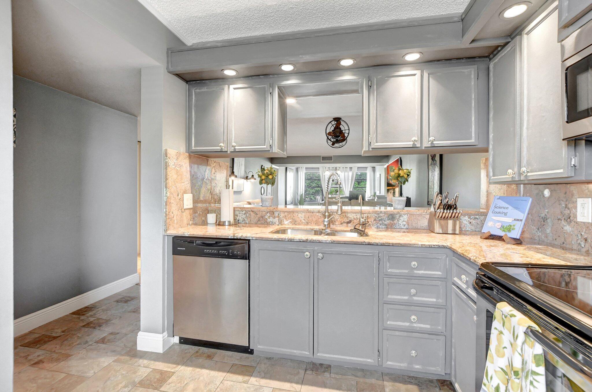 6025 Balboa Circle, Unit 303 Boca Raton, FL 33433 - Photo 5 of 23 a kitchen with granite countertop a sink and cabinets
