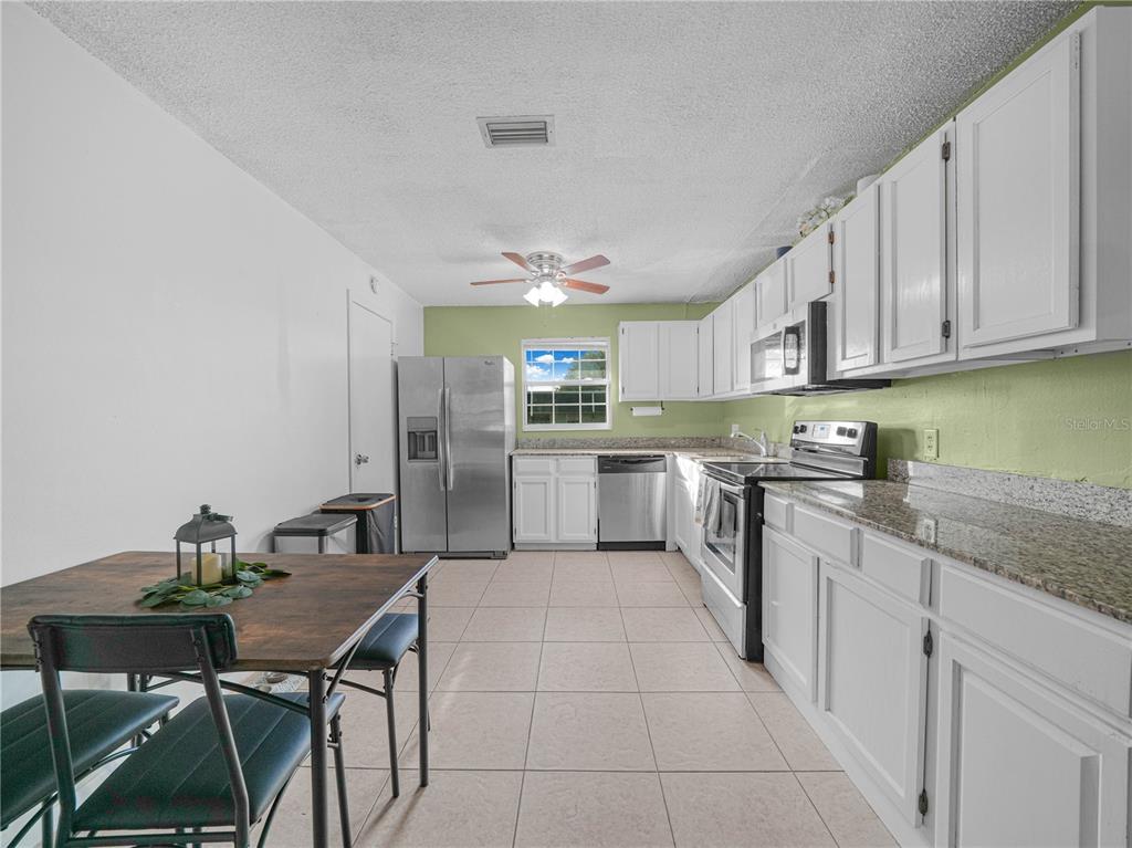 525 South Conway Road, Unit 100 Orlando, FL 32807 - Photo 11 of 23 a kitchen with stainless steel appliances granite countertop a sink counter space and cabinets