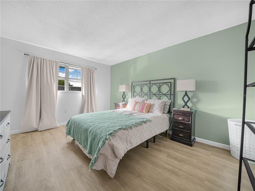 525 South Conway Road, Unit 100 Orlando, FL 32807 - Photo 12 of 23 a bedroom with a bed and wooden floor