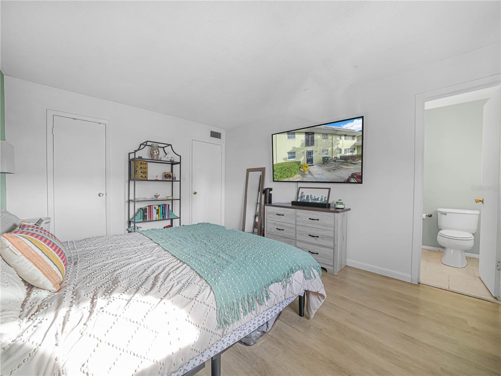 525 South Conway Road, Unit 100 Orlando, FL 32807 - Photo 13 of 23 a bedroom with a bed and a flat screen tv