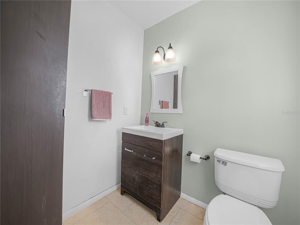 525 South Conway Road, Unit 100 Orlando, FL 32807 - Photo 14 of 23 a bathroom with a toilet sink vanity and mirror