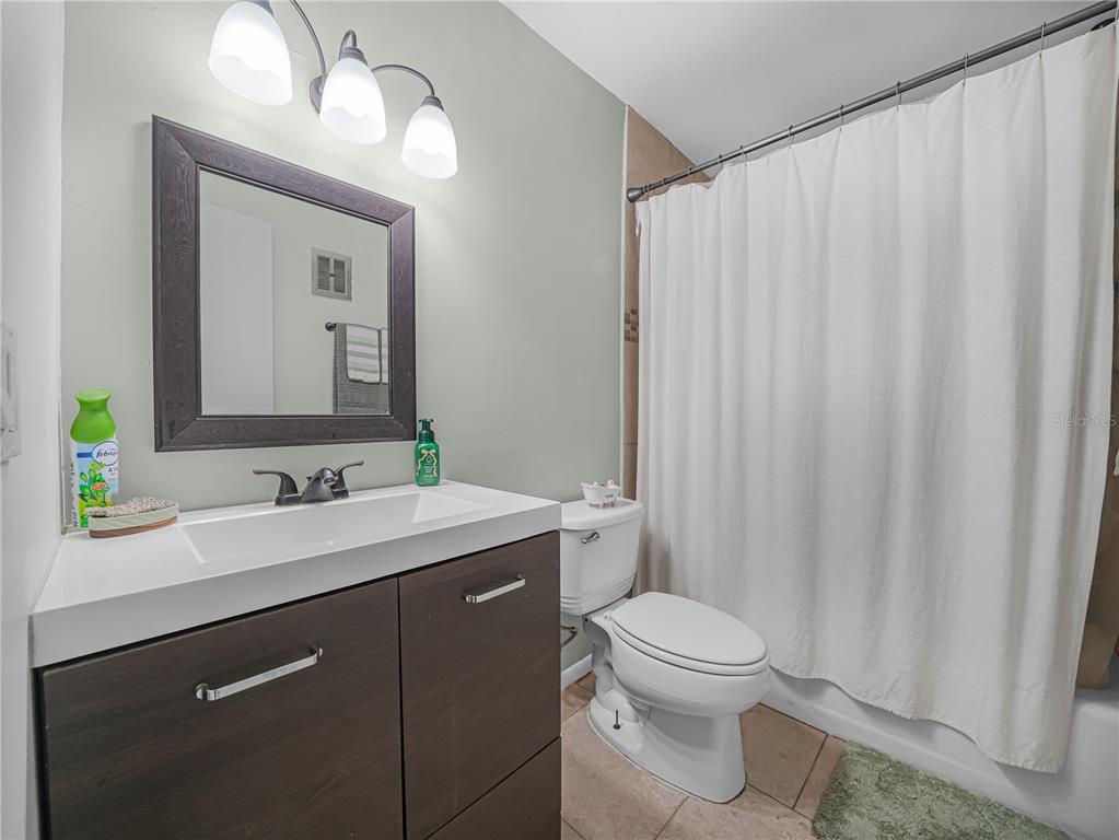 525 South Conway Road, Unit 100 Orlando, FL 32807 - Photo 15 of 23 a bathroom with a double vanity sink toilet and a mirror