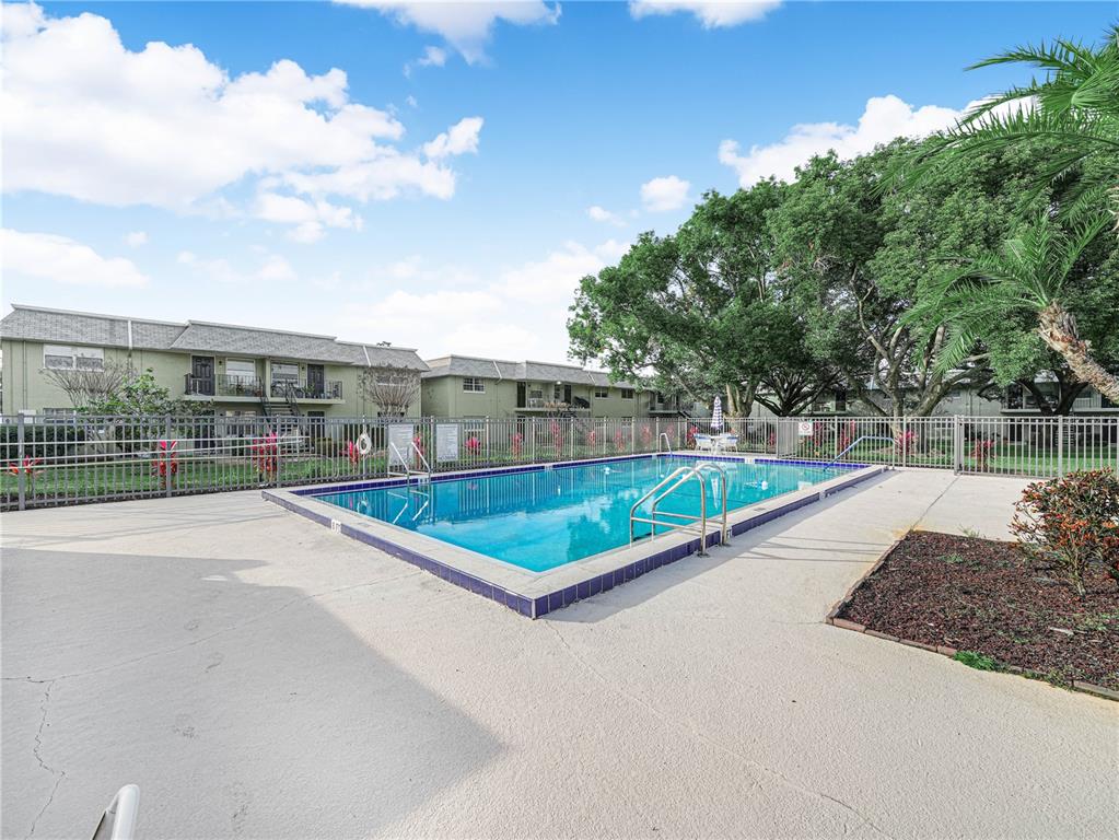 525 South Conway Road, Unit 100 Orlando, FL 32807 - Photo 22 of 23 a view of a swimming pool with a patio and a yard