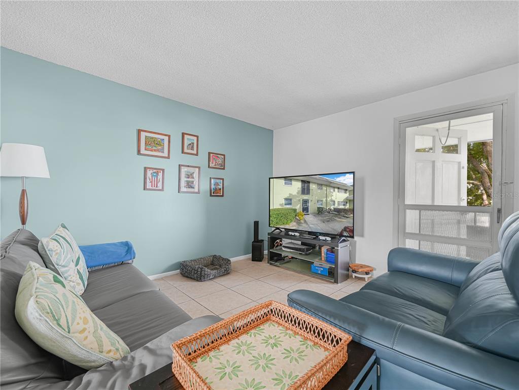525 South Conway Road, Unit 100 Orlando, FL 32807 - Photo 4 of 23 a living room with furniture and a flat screen tv