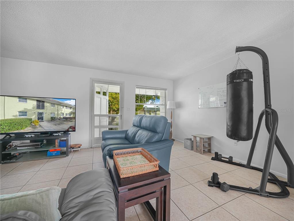 525 South Conway Road, Unit 100 Orlando, FL 32807 - Photo 7 of 23 a living room with furniture a flat screen tv and a window