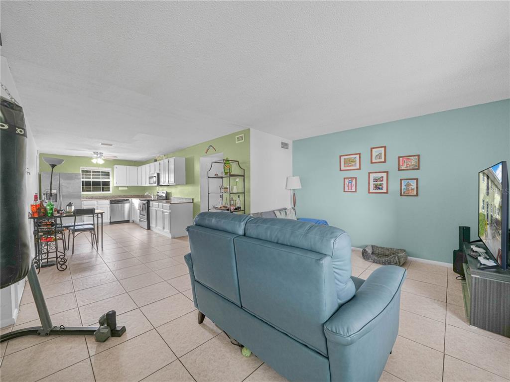 525 South Conway Road, Unit 100 Orlando, FL 32807 - Photo 8 of 23 a living room with furniture and a flat screen tv