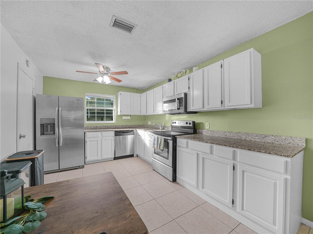 525 South Conway Road, Unit 100 Orlando, FL 32807 - Photo 10 of 23 a kitchen with white cabinets and white appliances