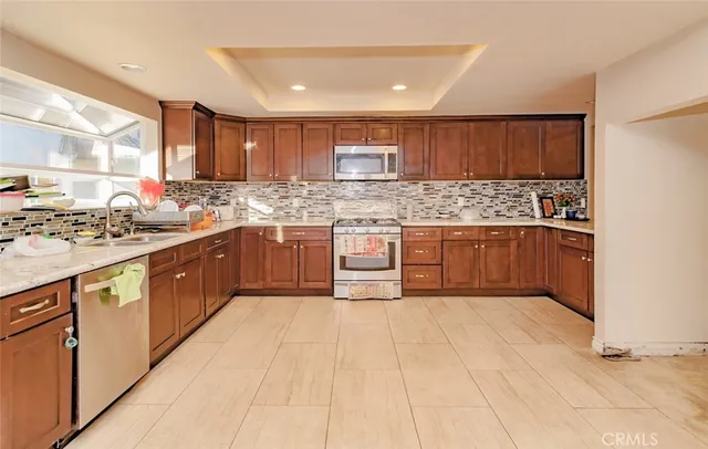 a large kitchen with stainless steel appliances granite countertop a stove and a sink