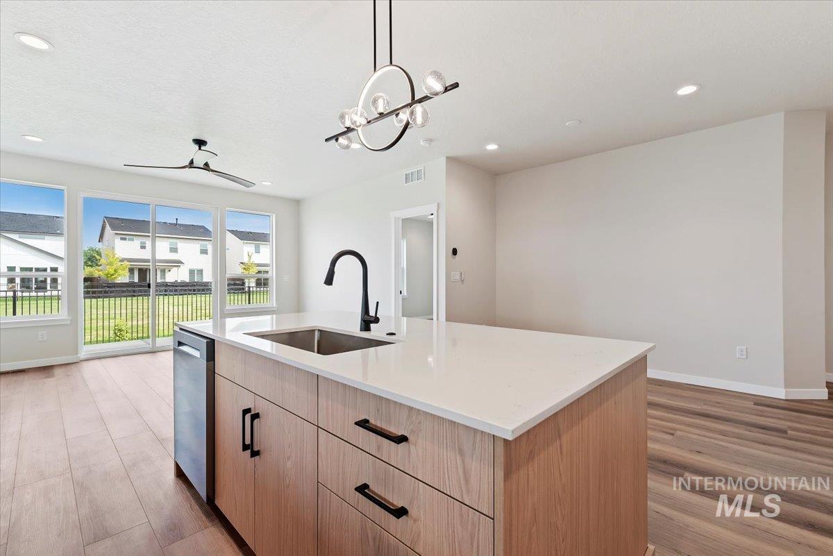 3866 West Spring House Lane Eagle, ID 83616 - Photo 10 of 33 Kitchen with light brown cabinets, recessed lighting, hanging light fixtures, light wood finished floors, and a center island with sink