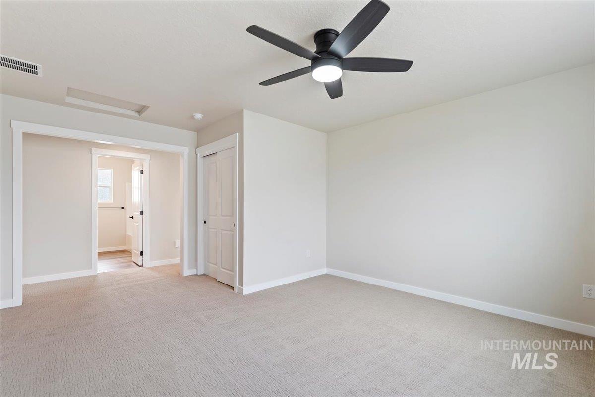 3866 West Spring House Lane Eagle, ID 83616 - Photo 14 of 33 Empty room with light carpet, attic access, and a ceiling fan