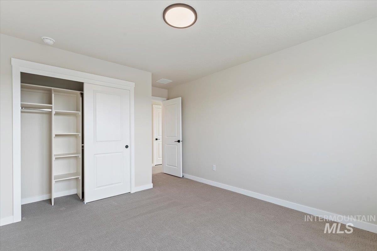 3866 West Spring House Lane Eagle, ID 83616 - Photo 18 of 33 Unfurnished bedroom with light colored carpet and a closet