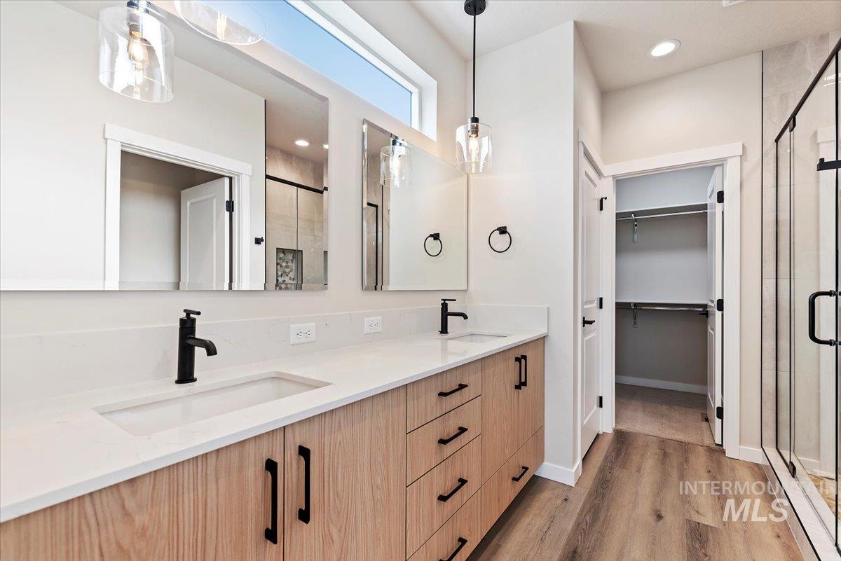 3866 West Spring House Lane Eagle, ID 83616 - Photo 21 of 33 Full bathroom with a shower stall, double vanity, light wood-style flooring, a spacious closet, and recessed lighting