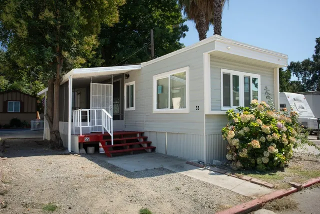 a front view of a house with a garden and plants