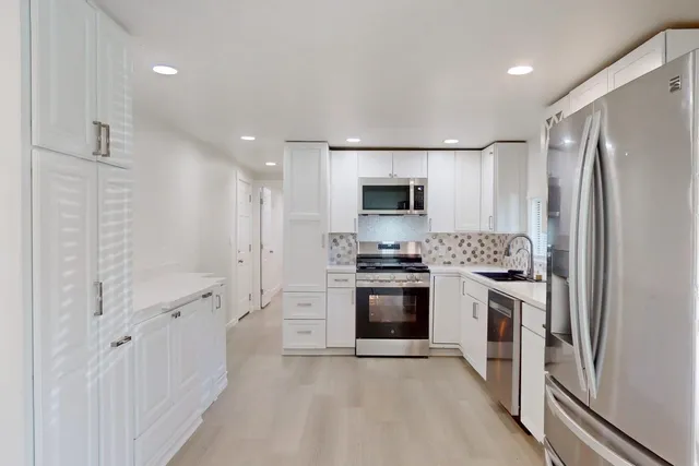 a kitchen with stainless steel appliances a refrigerator sink and stove