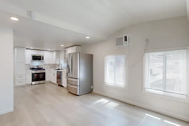 a kitchen with white cabinets and stainless steel appliances