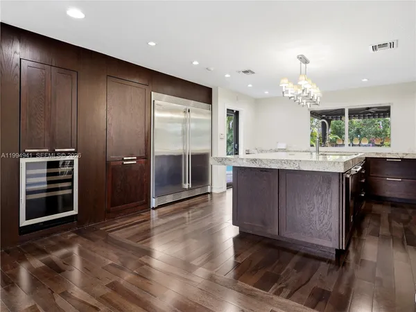 a kitchen with granite countertop kitchen island a sink appliances and a counter space