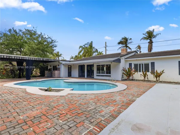 an aerial view of a house with swimming pool and a fountain