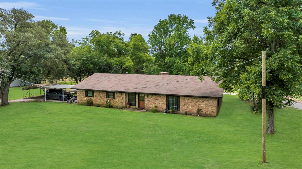 9822 Nasturtium Road Ore City, TX 75683 - Photo 16 of 37 a view of a house with a yard plants and large tree