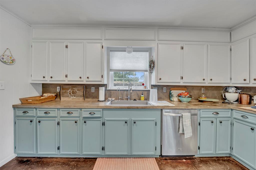 9822 Nasturtium Road Ore City, TX 75683 - Photo 22 of 37 a kitchen with cabinets appliances and a sink