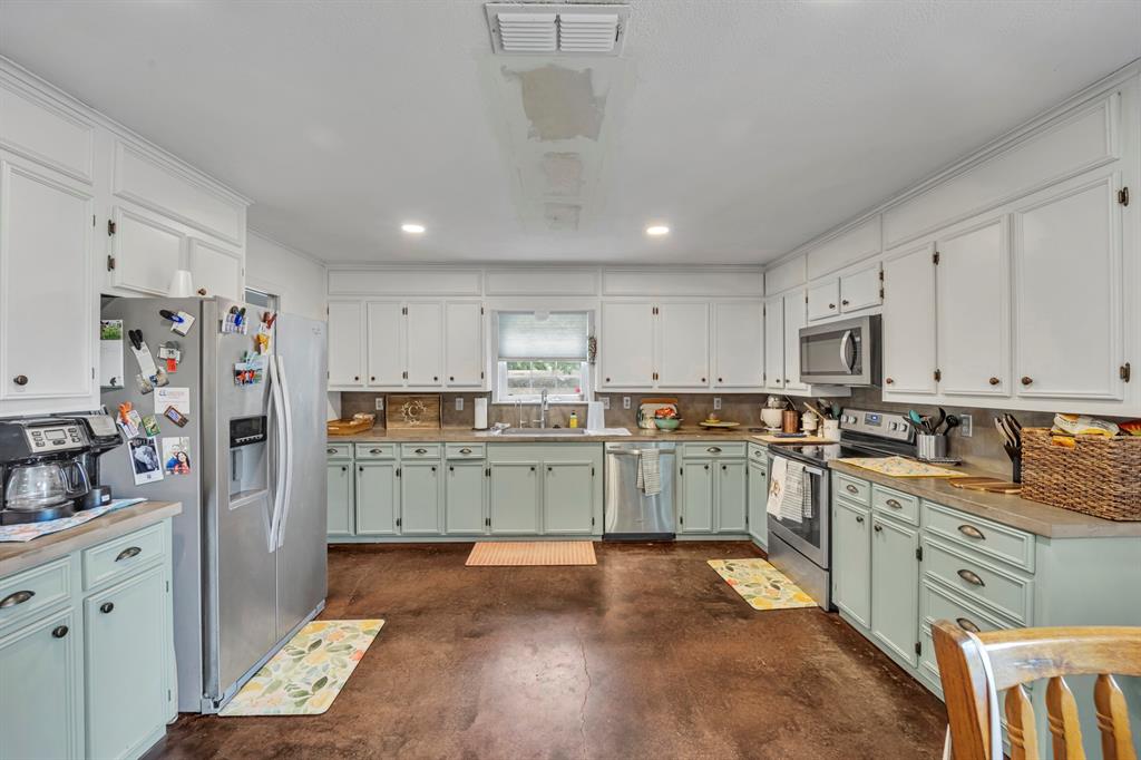 9822 Nasturtium Road Ore City, TX 75683 - Photo 23 of 37 a kitchen with cabinets and window
