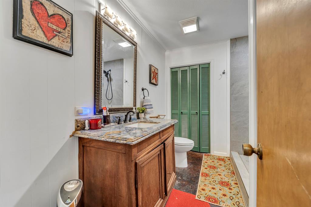 9822 Nasturtium Road Ore City, TX 75683 - Photo 27 of 37 a bathroom with a sink mirror vanity and toilet