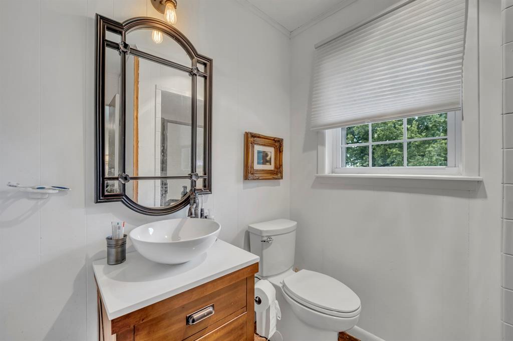 9822 Nasturtium Road Ore City, TX 75683 - Photo 30 of 37 a bathroom with a toilet a sink and a mirror