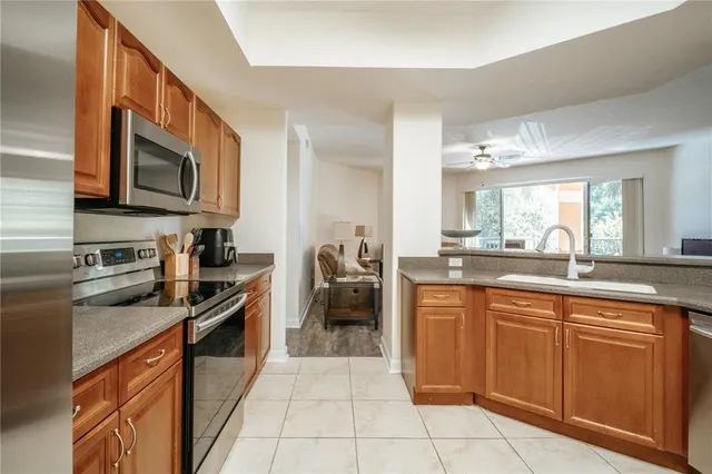 a kitchen with stainless steel appliances granite countertop a stove top oven a sink dishwasher and cabinets