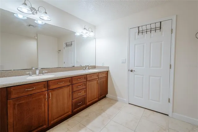 a spacious bathroom with a double vanity sink and a mirror