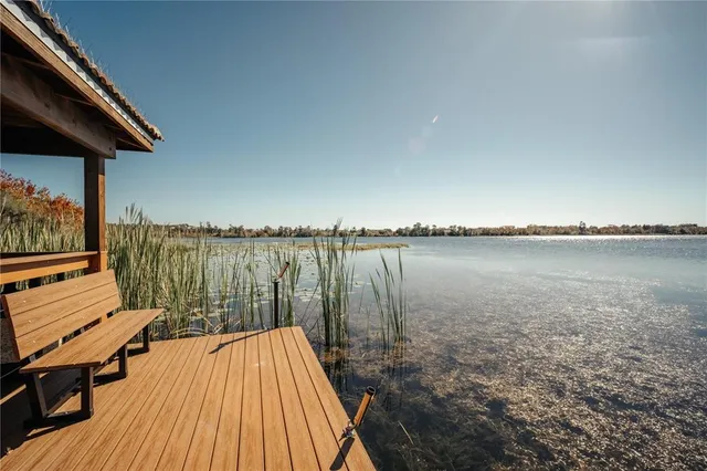 a view of a lake with wooden stairs and outdoor seating