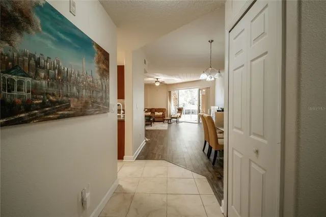 a view of a hallway and a livingroom with furniture