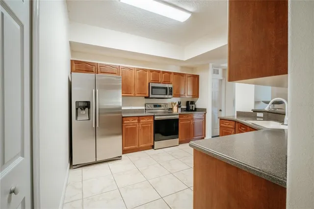 a kitchen with granite countertop a refrigerator and a sink
